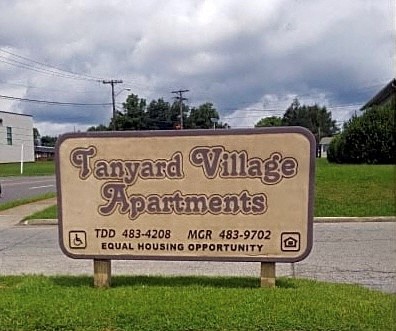 a sign in the grass that says taylor village apartments